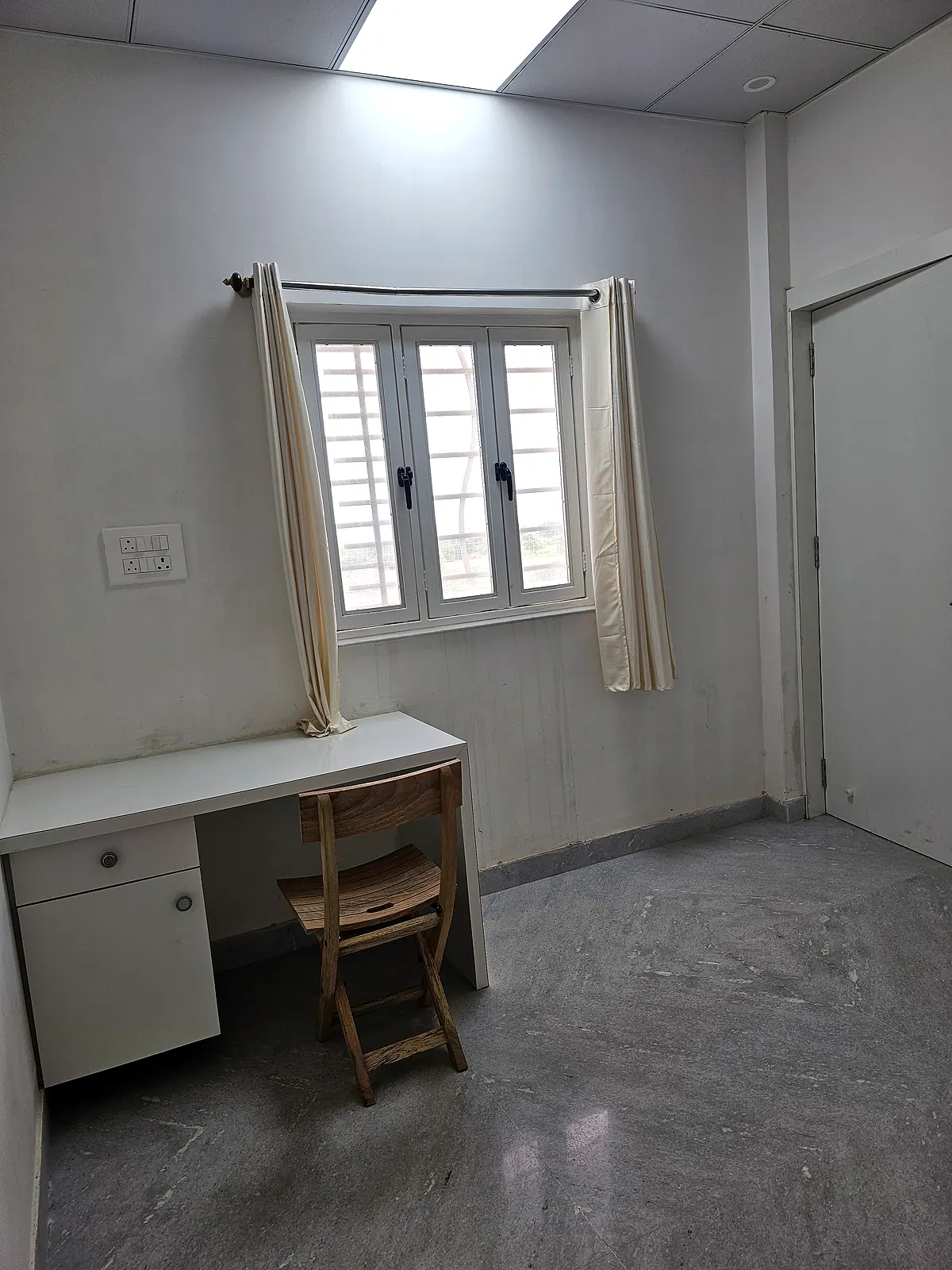 Window, curtains, study desk and wooden chair in the representative furnished room